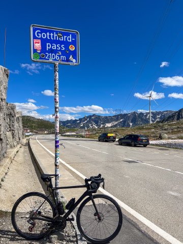 Factor bicycle leaning against the Gotthardpass sign near the top of the pass