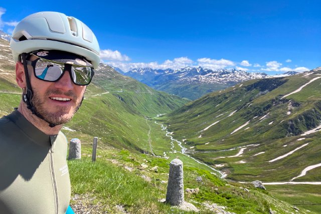 Cyclist along the road on the Furkapass overlooking Andermatt