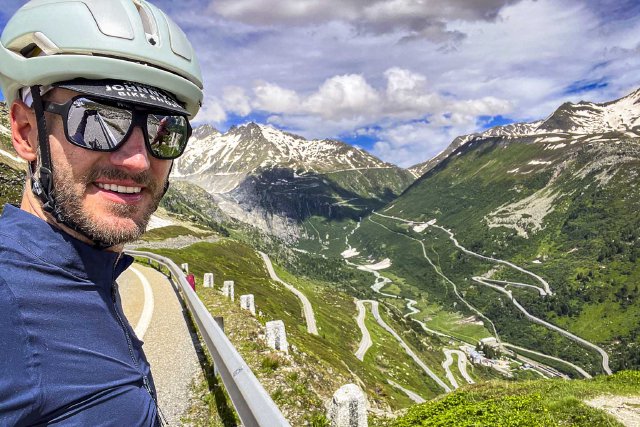Cyclist portrait at the top of the Grimselpass looking towards the Furkapass