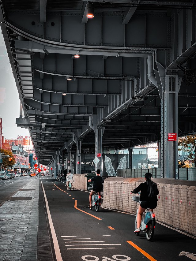 Bicycle riders riding along a bike path in East Manhattan, New York City.