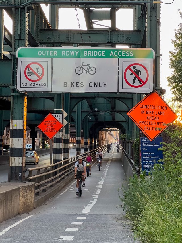 Bicycle riders riding on the east descent along the Queensboro bridge bike path in New York City