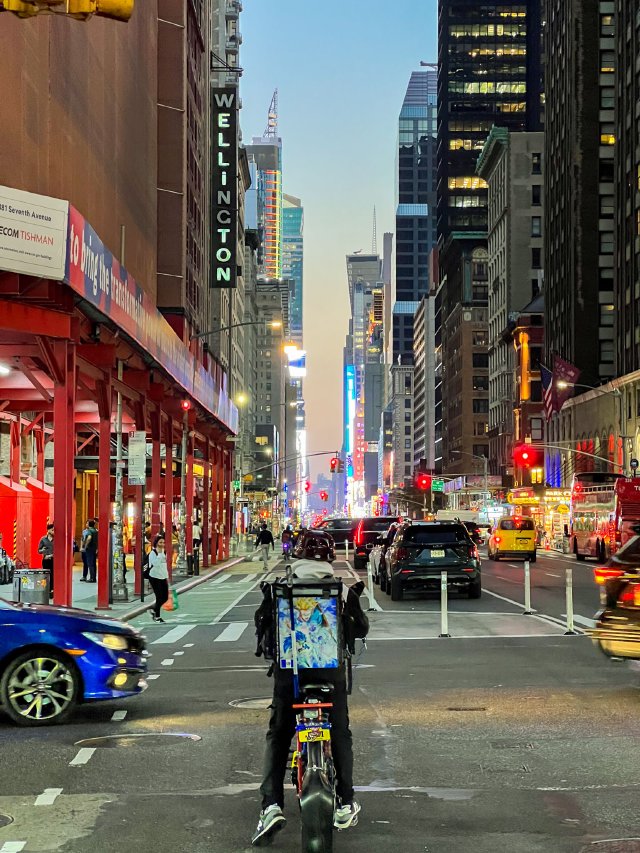 Delivery bicycle rider traveling through an intersection on 7th Ave in New York City on their way to Times Square