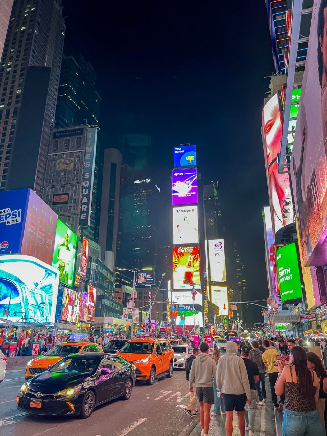 Masses of people and cars in Times Square at night